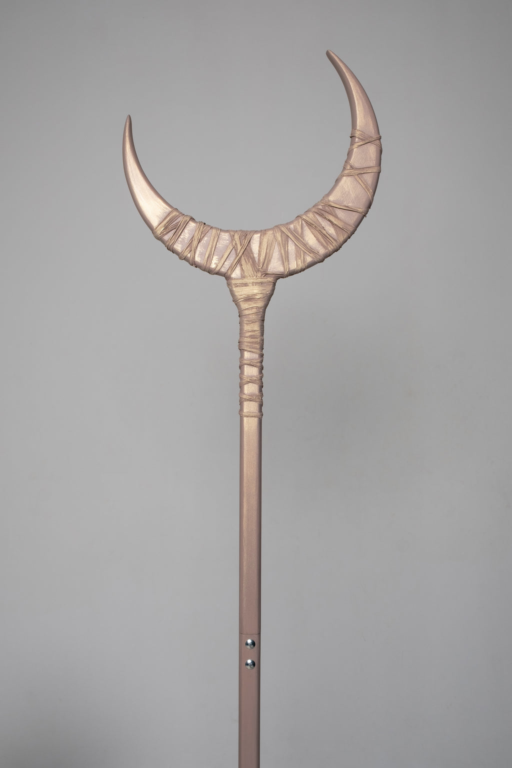 Decorative staff with a crescent moon design on a gray background