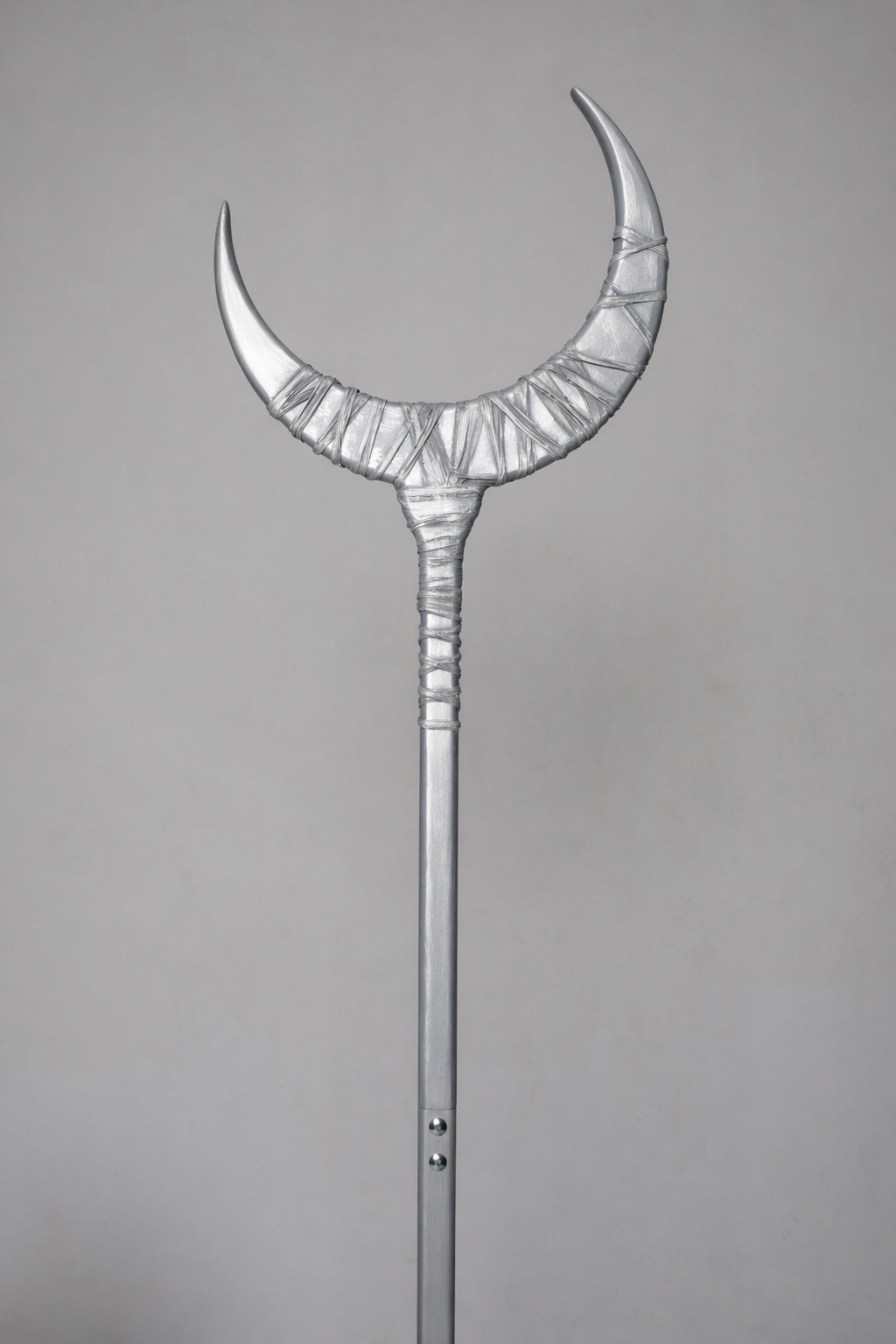 Decorative silver staff with a crescent moon design on a gray background
