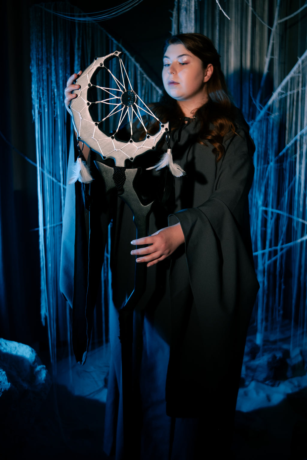 Close view of crescent dreamcatcher top with white web and pale feather accents