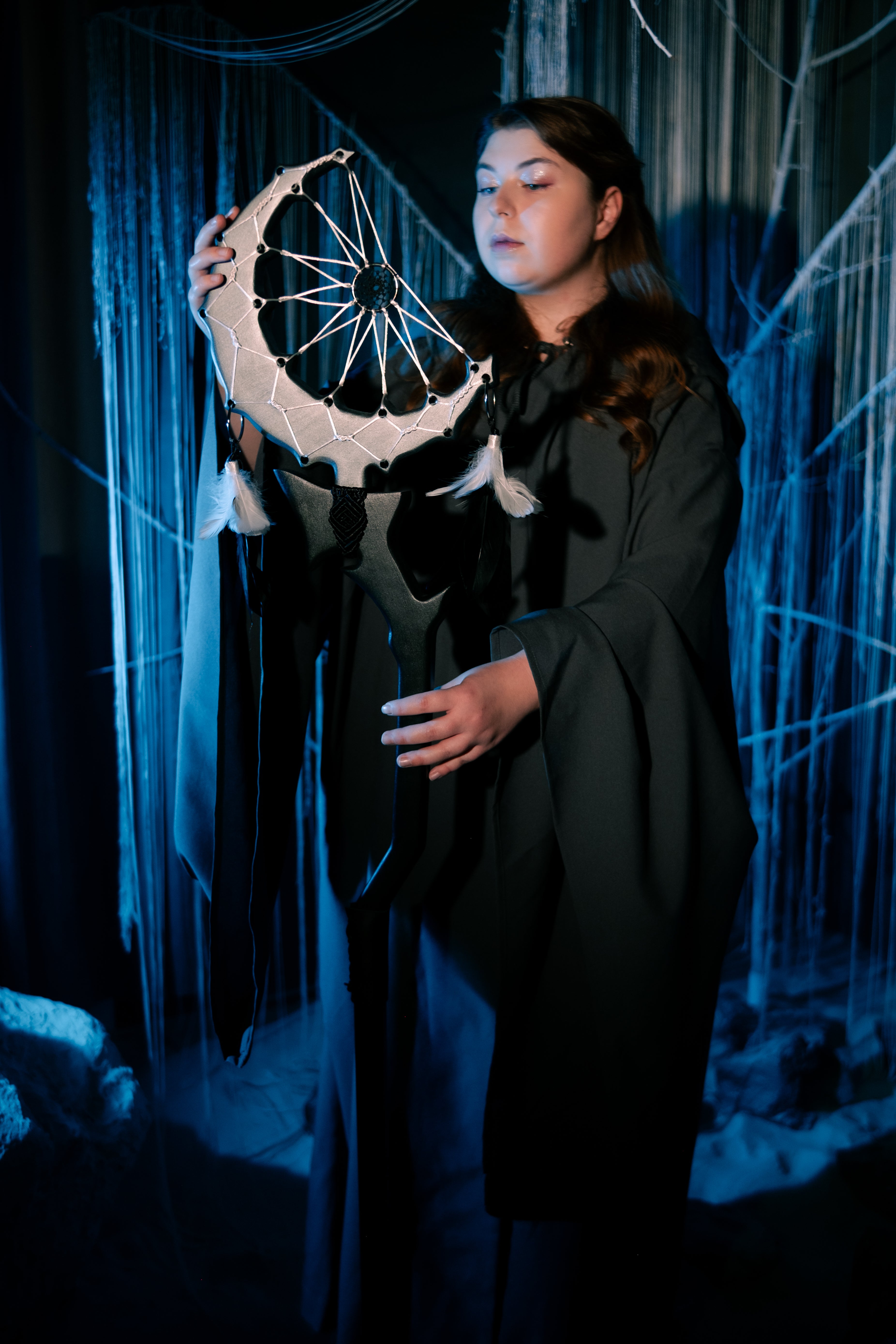 Close view of crescent dreamcatcher top with white web and pale feather accents