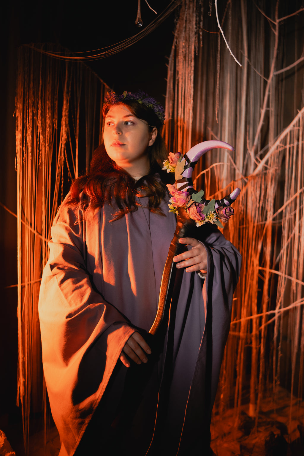 Person in a costume holdingStaff with soft decorative petal design