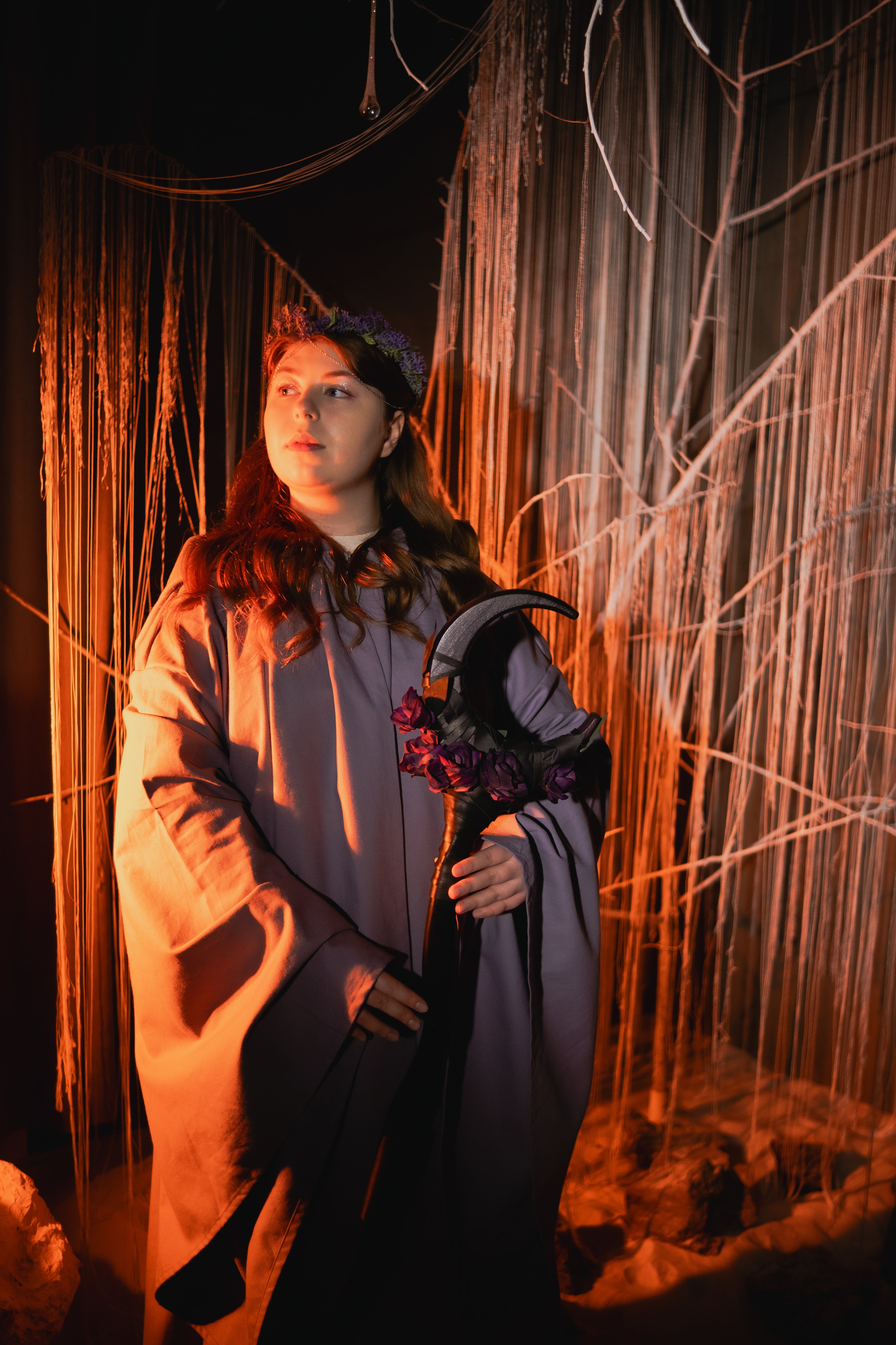 Person in a costume with a Velvet Eclipse Floral Crescent Moon Staff
