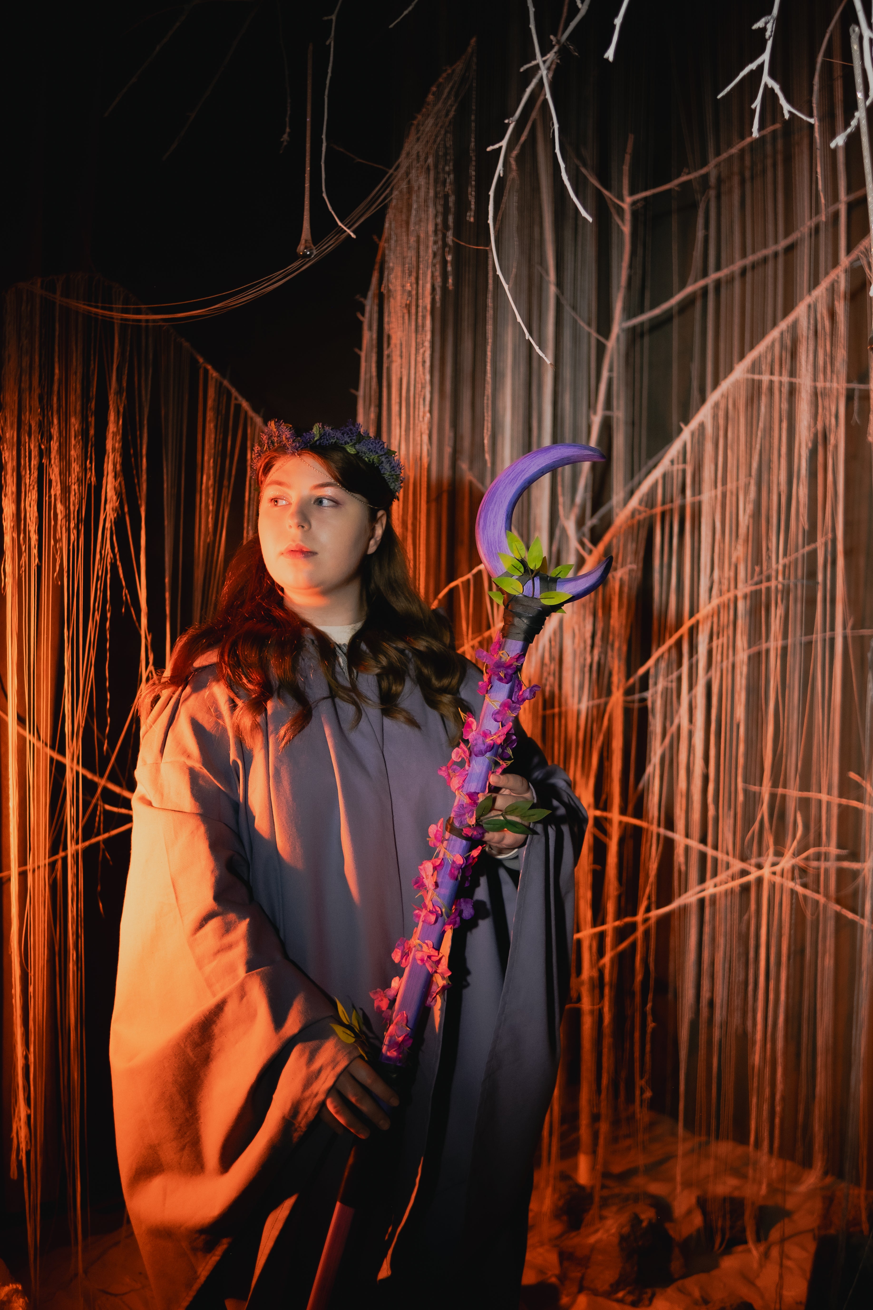 Person holding a purple weapon in a dark, eerie forest setting